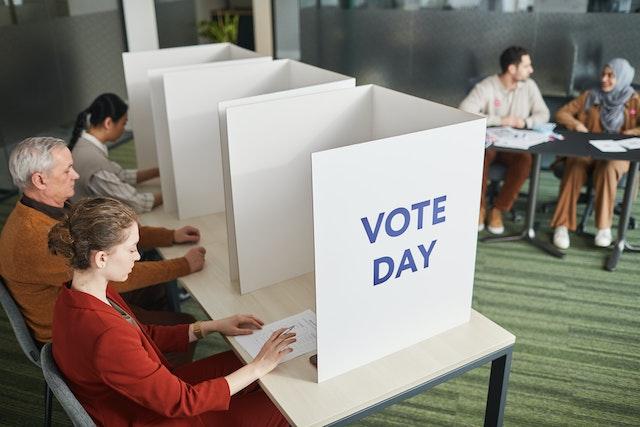 Photo of people sitting at botths to vote
