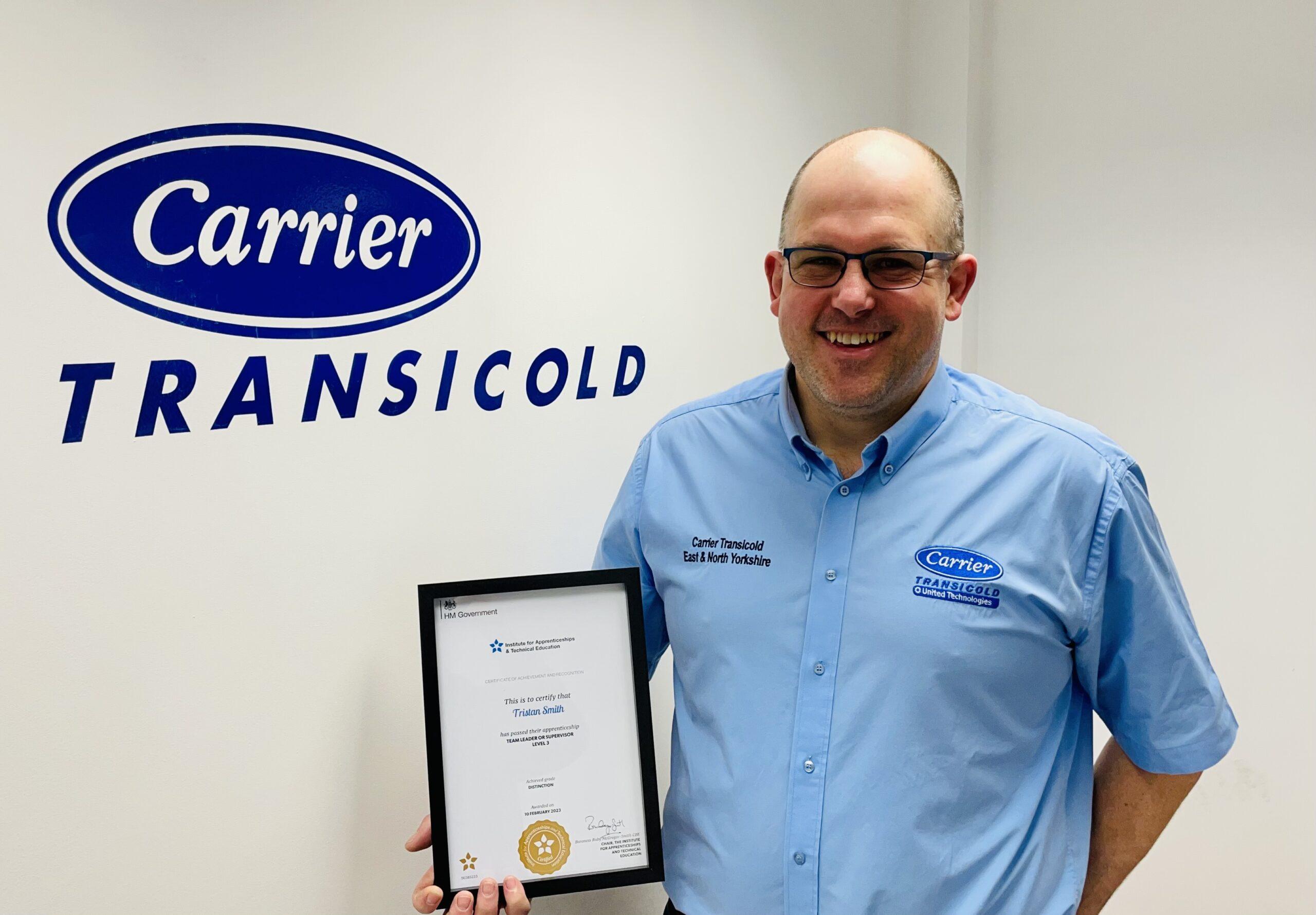 Photo of Tristan holding his apprenticeship certificate