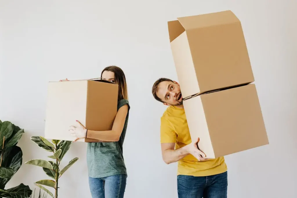 Photo of two people lifting boxes using the wrong lifting techniques