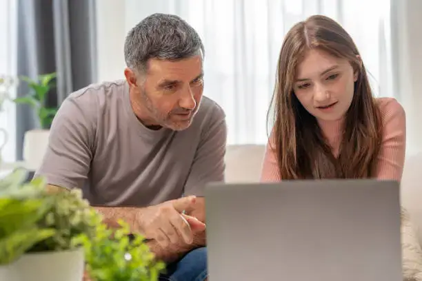 Photo of a father heloing his daughter research career options