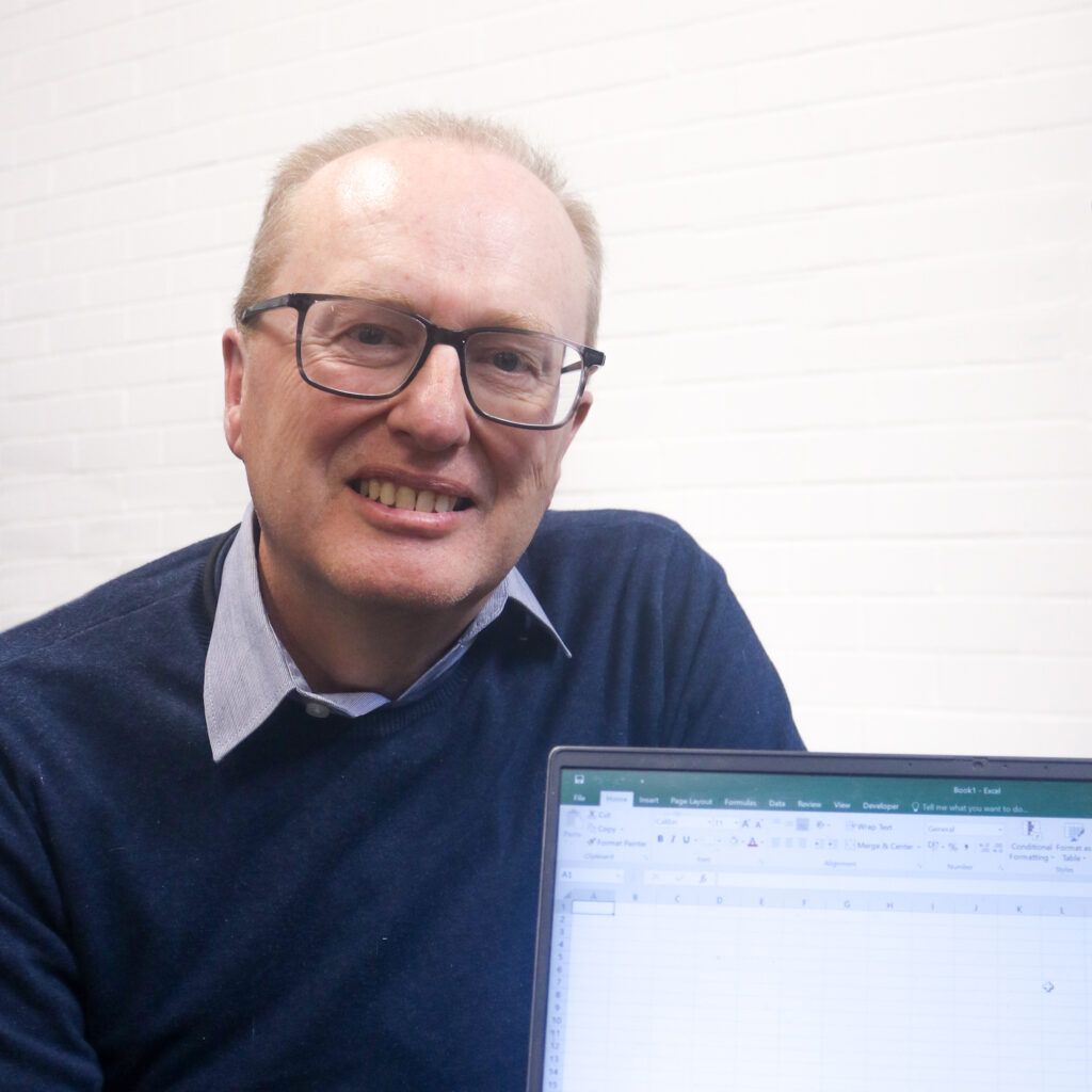 Meet the Staff: photo of Richard and his laptop, showing his technical expertise.