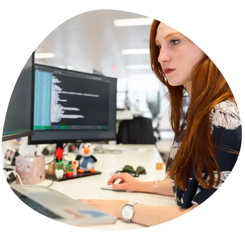 IT Support Apprenticeship: a woman sitting at a desk looking at code on a computer screen