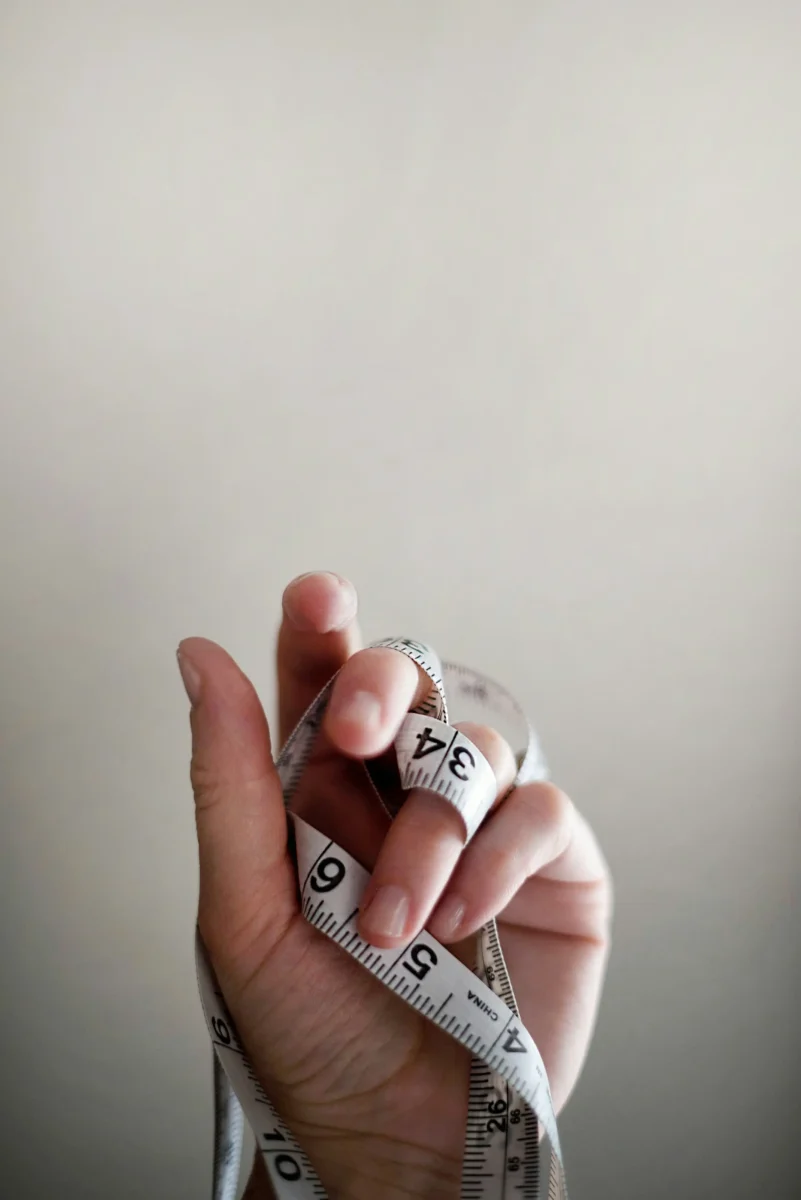 Photo of a person holding a measuring tape for Mental Health Awareness Week, relating to body image.